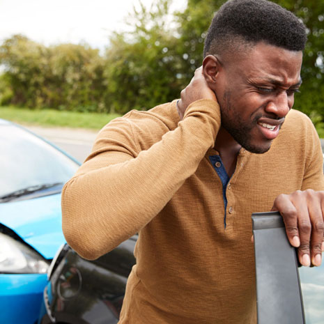 male motorist with whiplash injury exiting vehicle